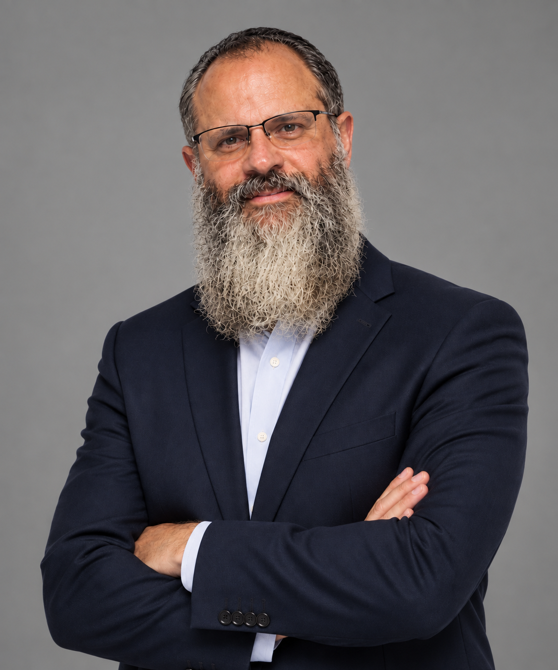 Portrait of Alon Zak, AI executive, in a navy blazer with arms crossed